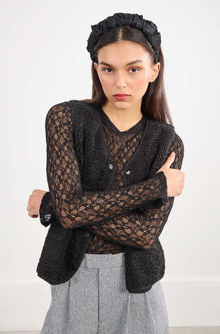 A woman with long dark hair, wearing the Molly Bracken Lace Stretch Top, poses with arms crossed and looks at the camera against a plain white background.