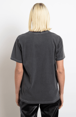 A person with straight, shoulder-length blonde hair is seen from behind, wearing the Daisy Street Betty Boop Hearts Graphic Tee-FINAL SALE in a boyfriend fit and black pants against a plain white background.