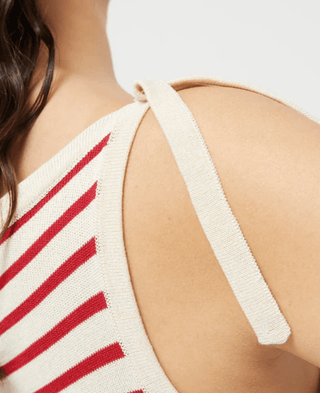 Close-up of a womans shoulder wearing the Compania Fantastica Nautical Stripe Knit Tank Top-FINAL SALE with red diagonal stripes, wide strap, and boat neckline. Her wavy dark hair drapes over her bare shoulder.
