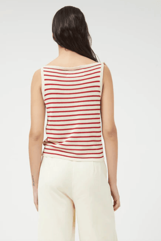 A person with long dark hair, seen from behind, wears the Compania Fantastica Nautical Stripe Knit Tank Top-FINAL SALE—sleeveless with red and white stripes—paired with loose cream pants against a plain light background.